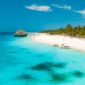 White sand beach with palm trees and turquoise water on Zanzibar
